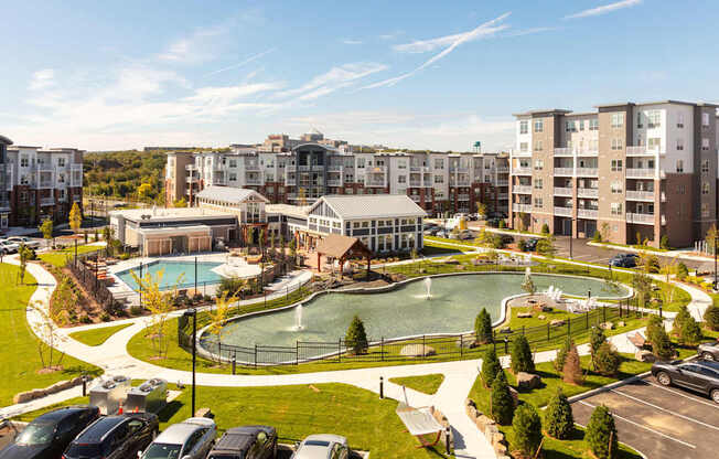 an aerial view of a park with a pool and buildings