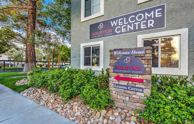 A building with a sign that says "Welcome Center" and "SOLSTICE APARTMENT HOMES".