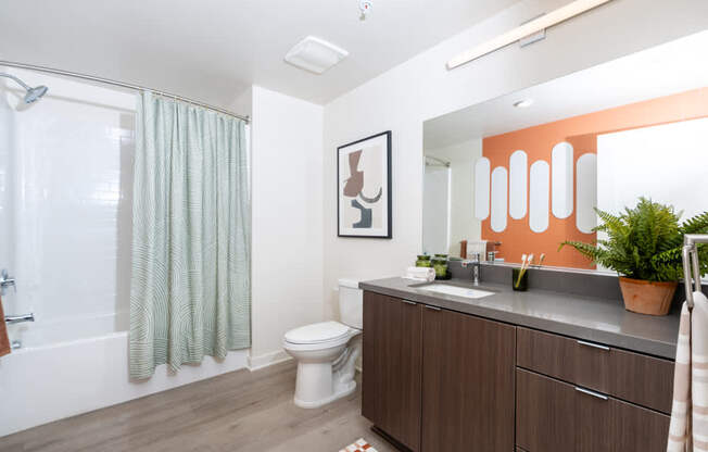 A bathroom with a toilet, sink, and shower.