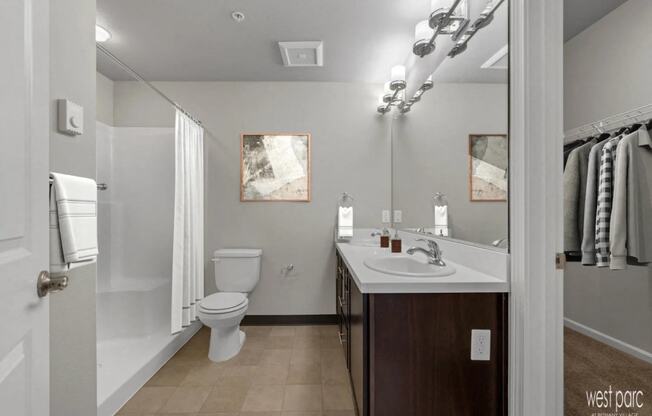 a bathroom with a toilet sink and shower and a mirror