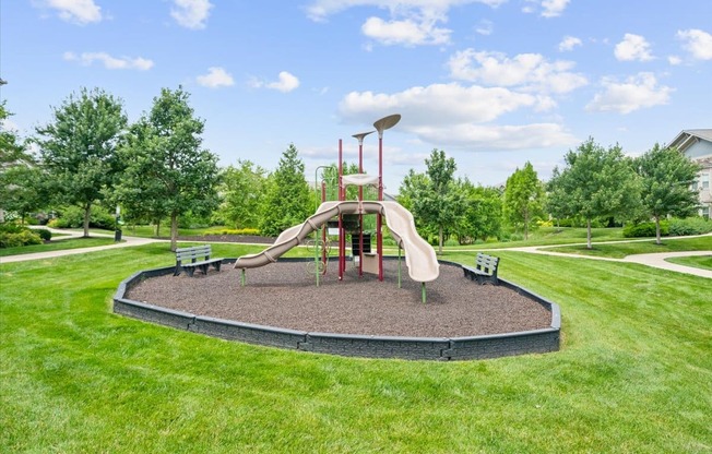 A playground with a slide and a red pole.