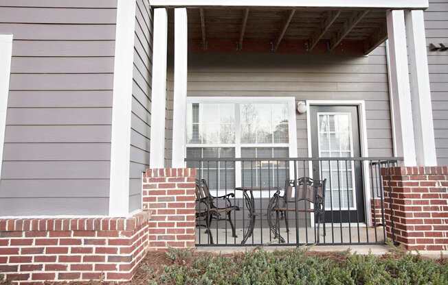 A house with a grey siding and a black metal railing.