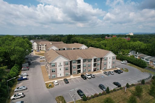 an aerial view of an apartment building overlooking a parking lot