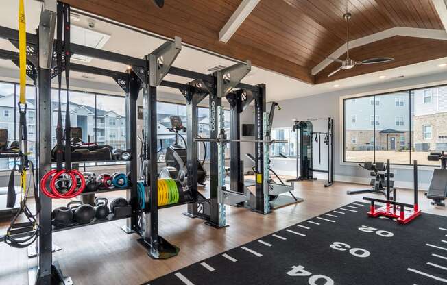 a home gym with weights and cardio equipment and a large window