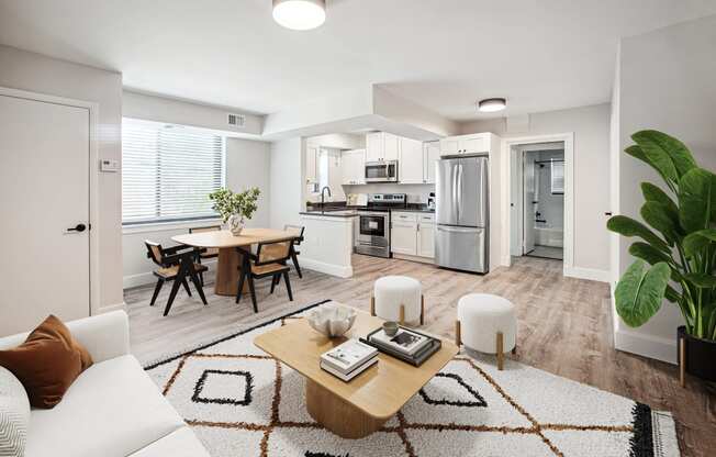 a living room and kitchen with white walls and wood flooring