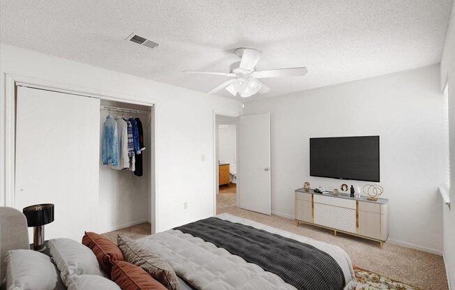 a bedroom with a bed and a ceiling fan