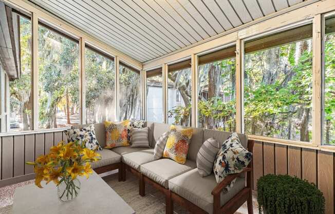 Greentree Apartments in Savannah, GA photo of a screened porch with a couch and a table with flowers