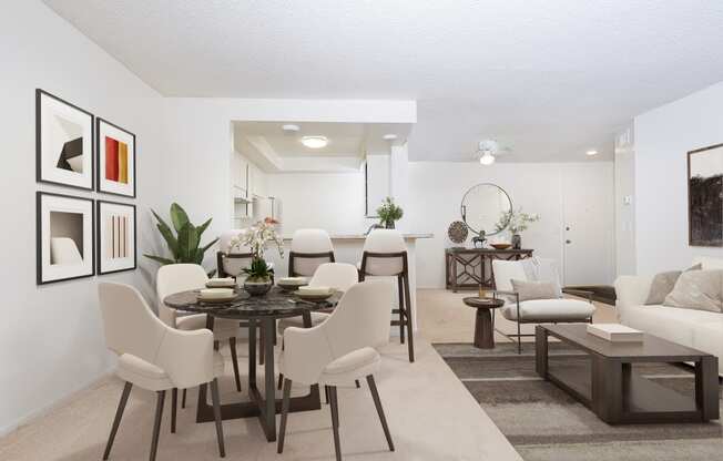 a living room and dining room with a table and chairs