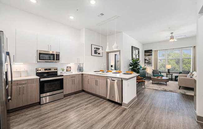 A modern kitchen with wooden floors and stainless steel appliances.