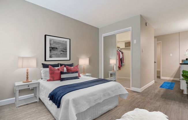 Bedroom with a mirrored closet doors, wood-inspired floors