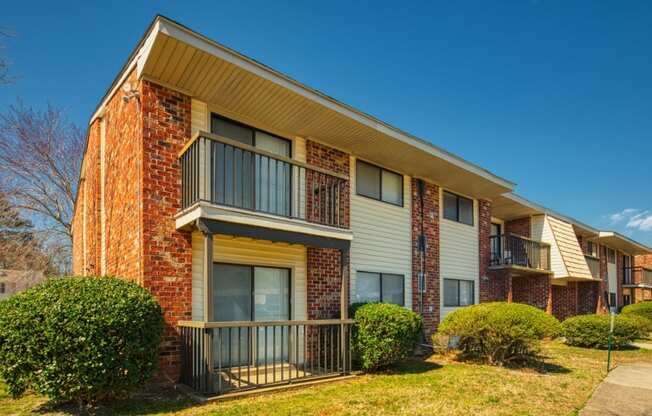 an apartment building with a balcony and a sidewalk