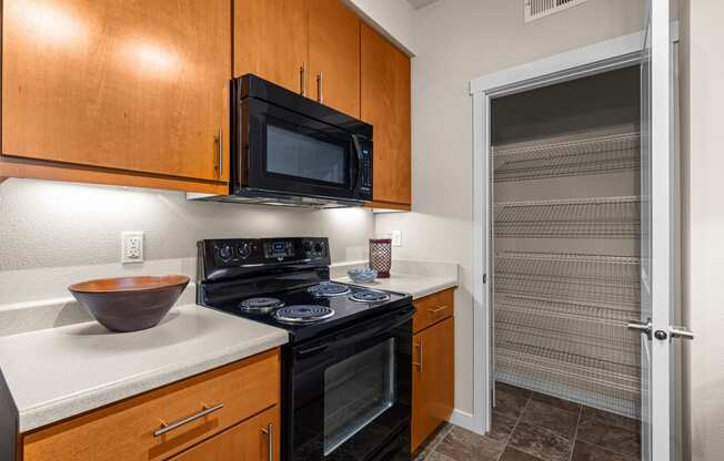 a kitchen with a stove and a microwave and a door to a closet