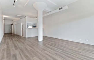 an empty living room with white walls and wood flooring