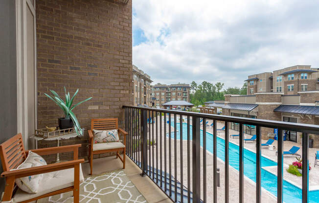 a balcony with a swimming pool and a patio with chairs at Residence at Riverwatch, Agusta