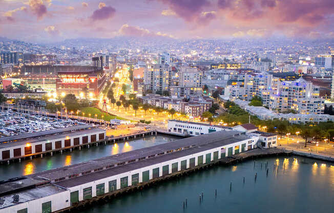 A cityscape at dusk with a marina in the foreground.