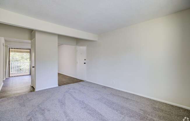 an empty living room with white walls and carpet