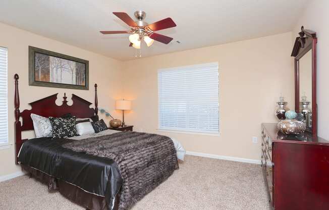 a bedroom with a large bed and a ceiling fan