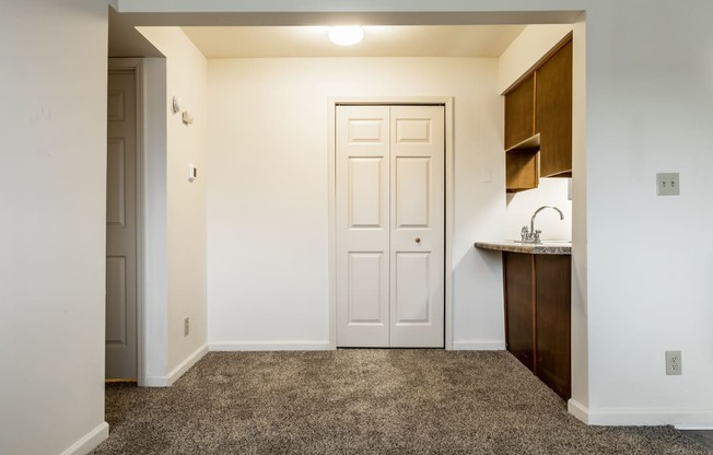 an empty room with a door and a kitchen at Pheasant Run in Lafayette, IN 47909