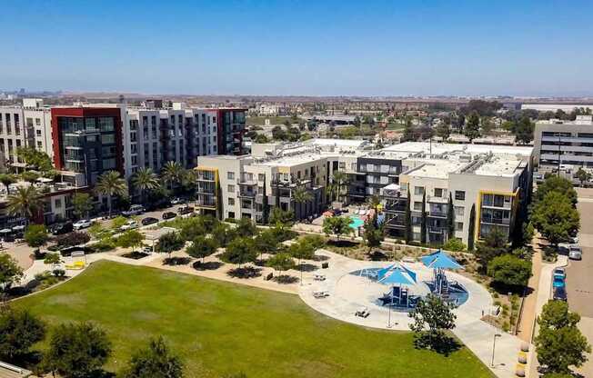 A large building complex with a pool in the middle of a grassy area.