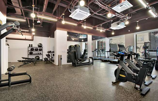 a gym with various exercise equipment and lights on the ceiling