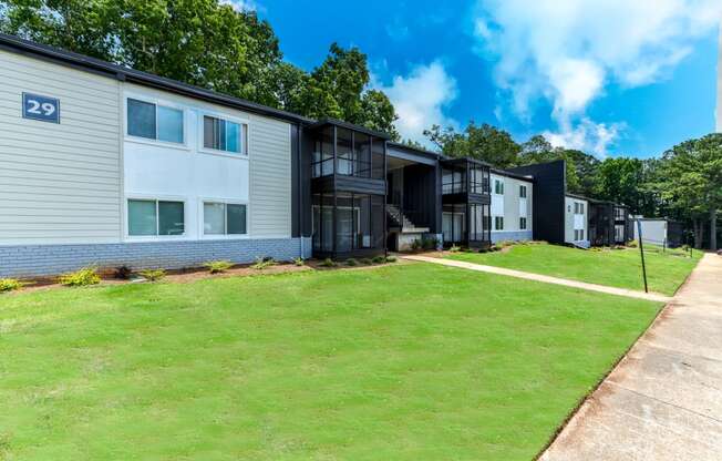 a row of apartment buildings with a green lawn in front of them