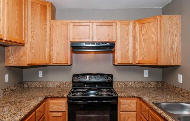 a kitchen with wooden cabinets and granite countertops