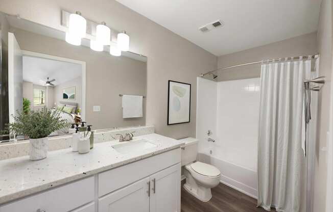 a bathroom with white cabinets and a white shower curtain