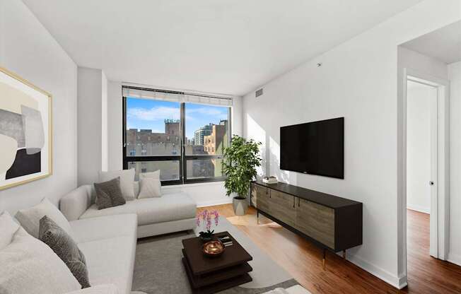 A modern living room with a large window and a flat screen TV.