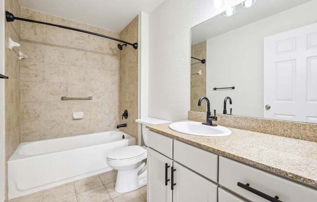A bathroom with a white tub, toilet, and sink.