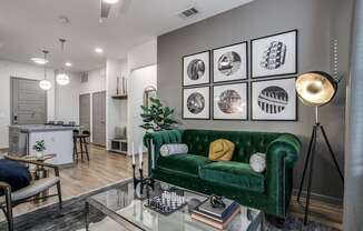 a living room with a green couch and a glass table