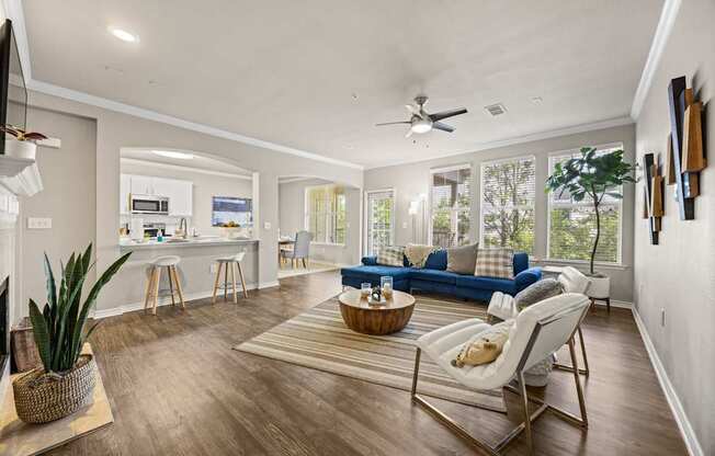 A living room with a blue couch and a white chair.