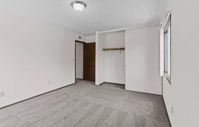 a bedroom with white walls and carpet