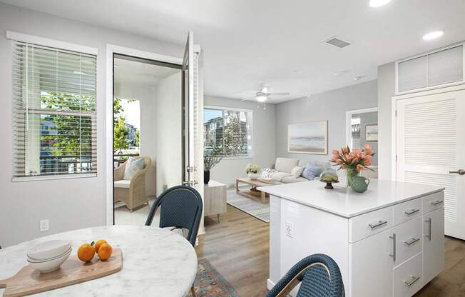 A kitchen with a table and chairs in front of a window.