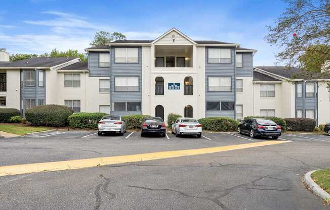 a large apartment building with cars parked in front of it