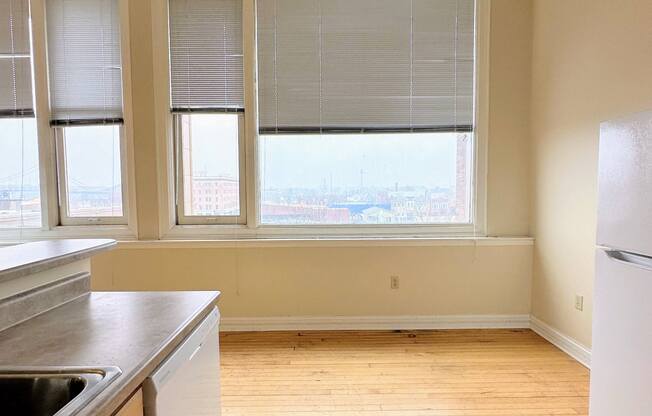 an empty kitchen with wood floors and a large window