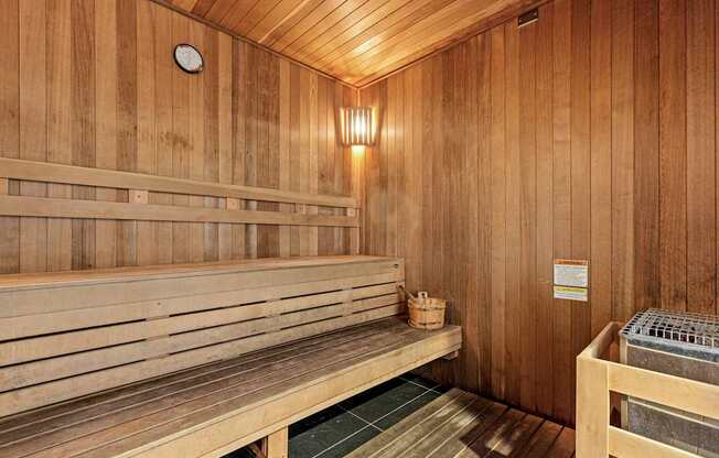 A wooden sauna with benches and a heater.