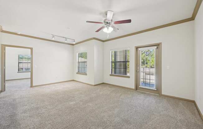 A room with a ceiling fan and carpeted floor.