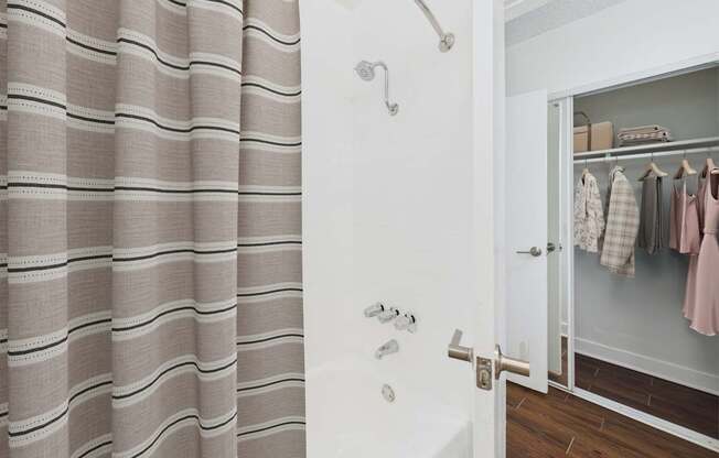 A bathroom with a shower curtain and a white door.