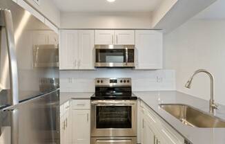 a kitchen with white cabinets and stainless steel appliances
