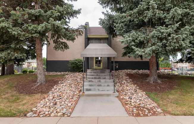 the front of a house with trees and a sidewalk