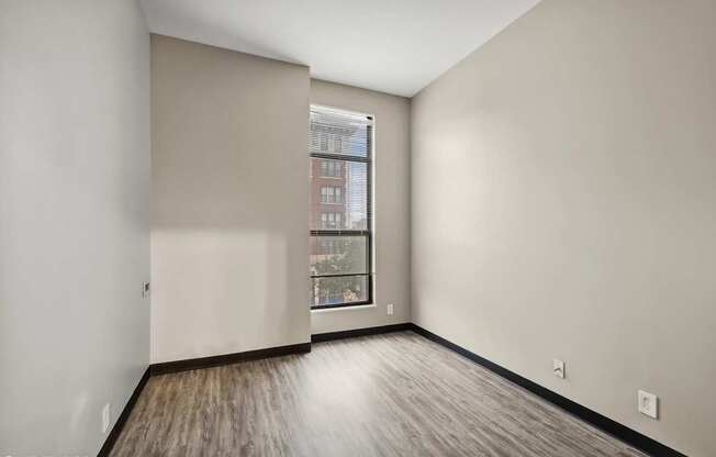 an empty room with white walls and a window