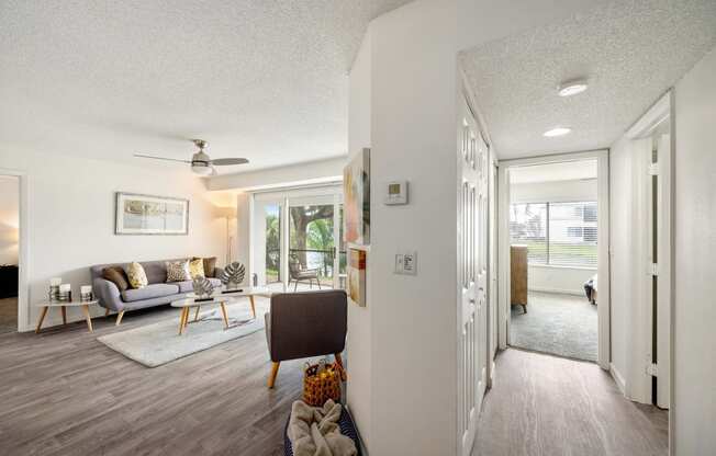 the living room and dining room of a house with white walls and wood floors