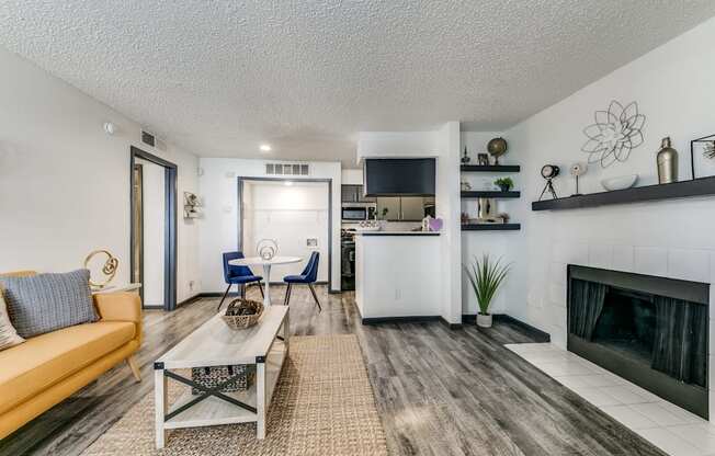 an open living room with a fireplace and a kitchen