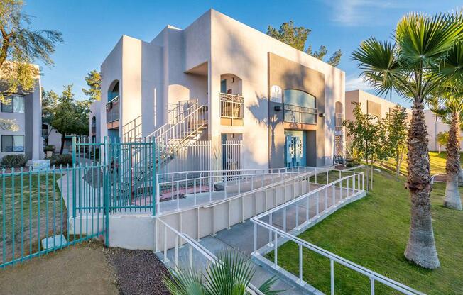 A modern building with a white exterior and a blue gate.