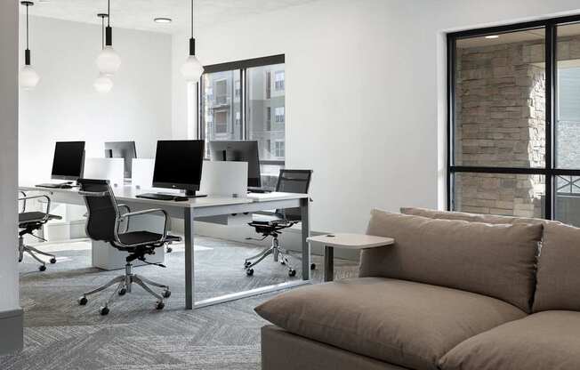 A modern office space with a couch, chairs, and desks.