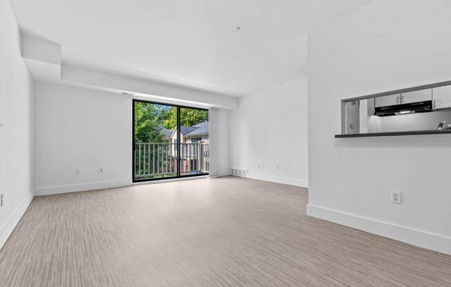 a living room with a sliding glass door and a balcony