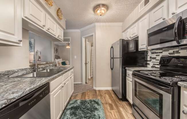 a kitchen with stainless steel appliances and marble counter tops at Highland Ridge Apartments, Overland Park , 66210