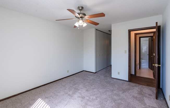 a bedroom with white walls and a ceiling fan. Eagan, MN Glen Pond Apartments