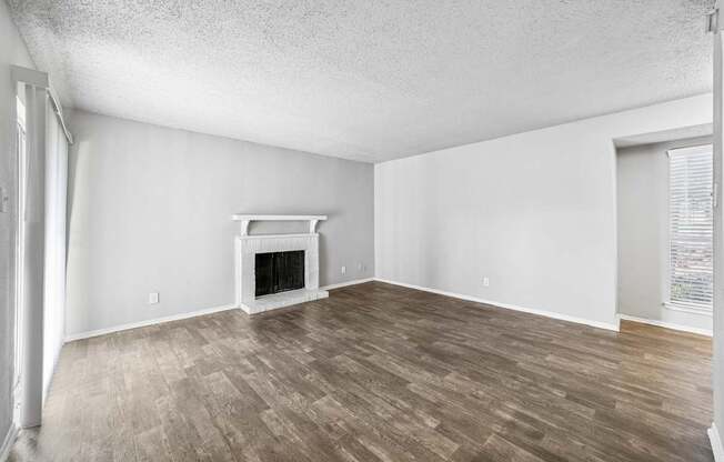 A room with a fireplace and wood flooring.