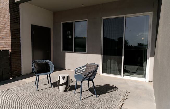 A patio with two chairs and a table.
